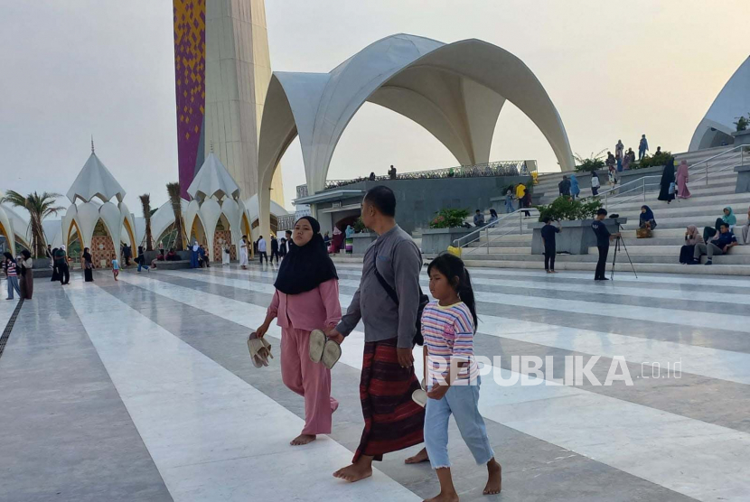 Sejumlah warga menghabiskan waktu ngabuburit jelang berbuka puasa di Masjid Al Jabbar, Kota Bandung, Kamis (23/3/2023). Sebagian warga tadarus Alquran, swafoto di kawasan masjid dan duduk-duduk di taman.