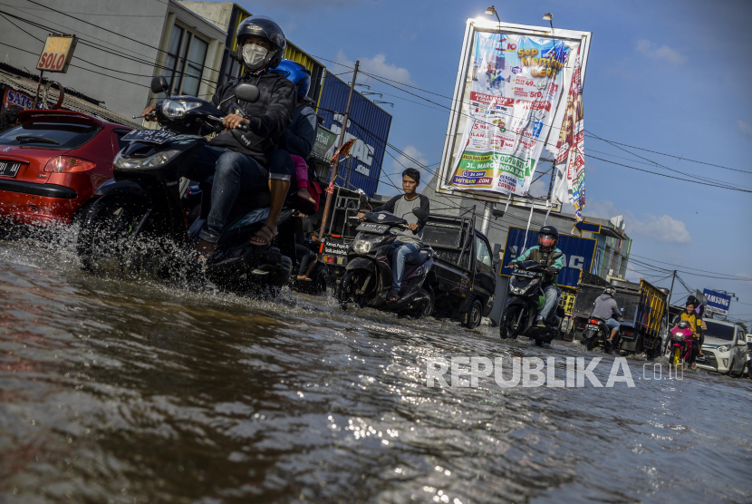 (ILUSTRASI) Pengguna kendaraan melintasi genangan banjir di kawasan perempatan Mampang, Kota Depok, Jawa Barat. 