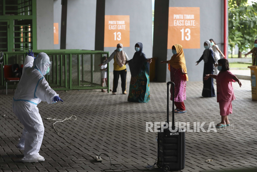  Seorang petugas kesehatan dengan pakaian pelindung melakukan latihan bersama pasien COVID-19 di Stadion Patriot Candrabhaga baru-baru ini diubah menjadi pusat isolasi bagi orang-orang yang menunjukkan gejala virus di Bekasi di pinggiran Jakarta, Indonesia, Rabu, 6 Januari 2021 .