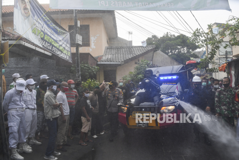 Anggota kepolisian dengan mengenakan hazmat menyemprotkan cairan disinfektan di kawasan Petamburan III, Jakarta Pusat, Minggu (22/11/2020). Penyemprotan tersebut dilakukan menyusul adanya temuan kasus terkonfirmasi positif COVID-19 di kawasan Petamburan. 