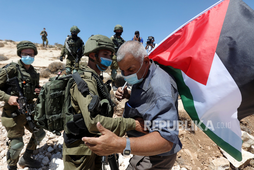 Tentara Israel berdebat dengan warga Palestina 