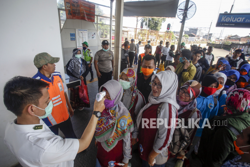Petugas memeriksa suhu tubuh calon penumpang KRL Commuter Line di Stasiun Bojong Gede, Bogor, Jawa Barat, Selasa (17/3/2020). .