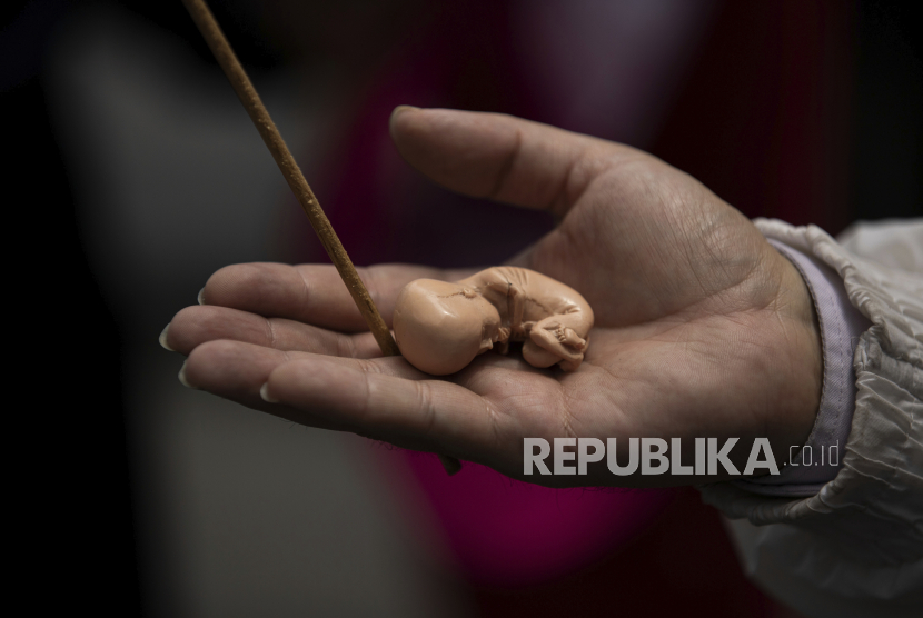Seorang aktivis menentang aborsi memegang model janin. (Ilustrasi)