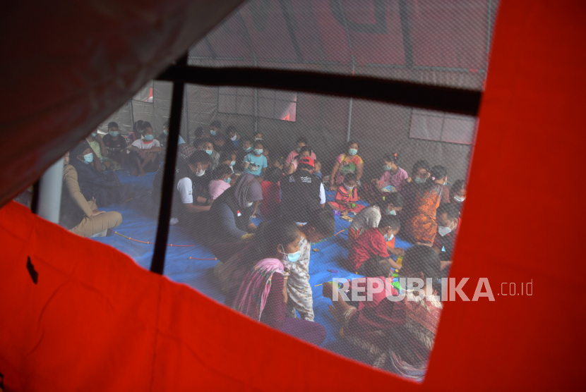 Sejumlah anak pengungsi tanah longsor didampingi orang tuanya bermain bersama relawan di dalam tenda pengungsian di kawasan SDN 3 Ngetos, Nganjuk, Jawa Timur, Selasa (16/2/2021). Sedikitnya 141 warga terdampak tanah longsor mengungsi di tempat tersebut. 