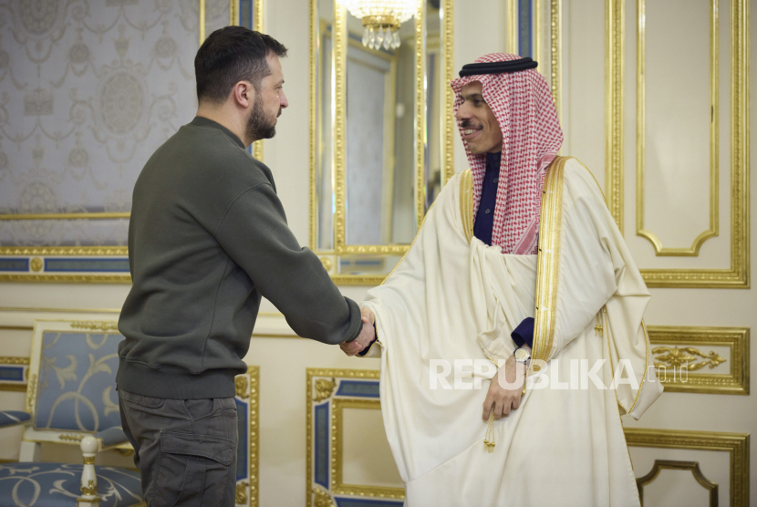 Dalam foto yang disediakan oleh Kantor Pers Kepresidenan Ukraina ini, Presiden Ukraina Volodymyr Zelenskyy (kiri) dan Menteri Luar Negeri Arab Saudi Pangeran Faisal bin Farhan al-Saud berjabat tangan saat pertemuan mereka di Kyiv, Ukraina, Ahad (26/2/2023). 