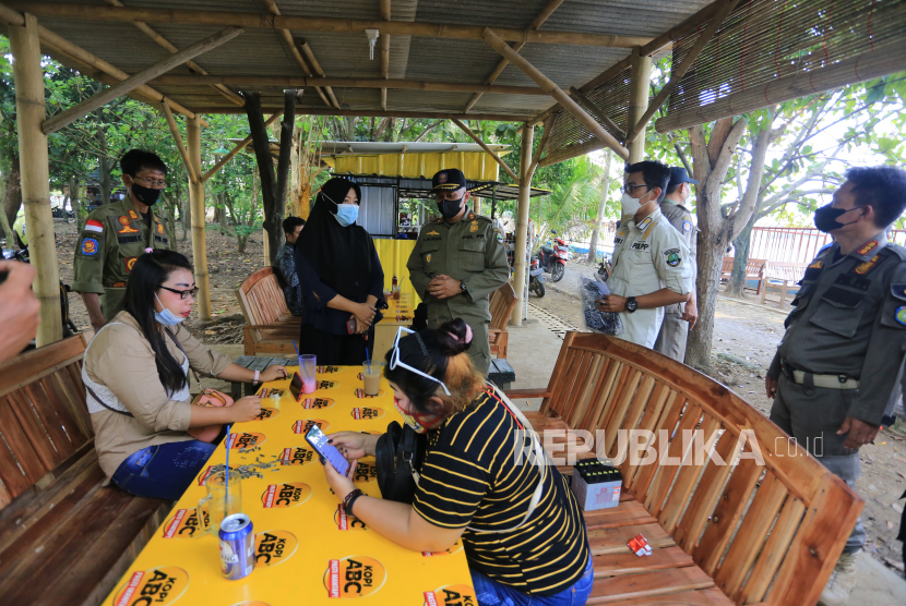 Petugas Satpol PP membagikan masker saat sosialisasi protokol kesehatan di Indramayu, Jawa Barat, Kamis (25/11/2021). Kegiatan sosialisasi itu sekaligus memantau kepatuhan masyarakat terhadap protokol kesehatan dan sebagai upaya pencegahan penyebaran COVID-19. 