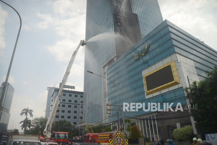 Petugas pemadam kebakaran berusaha memadamkan api saat terjadi kebakaran di Gedung K-Link Tower, Gatot Subroto, Jakarta, Sabtu (15/7/2023).