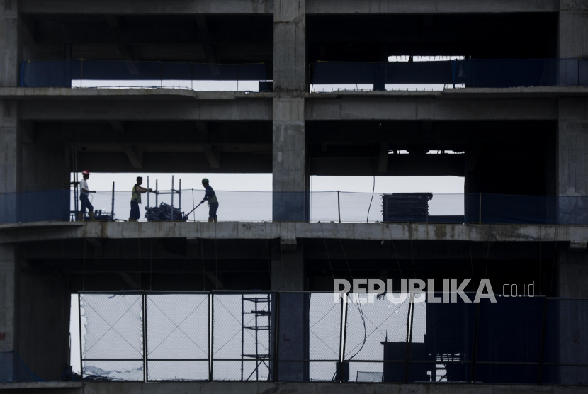 Pekerja menyelesaikan pembangunan gedung bertingkat di Jakarta, Senin (28/11/2022). Arus modal asing yang keluar dari Indonesia diperkirakan hanya bersifat temporer atau sementara.