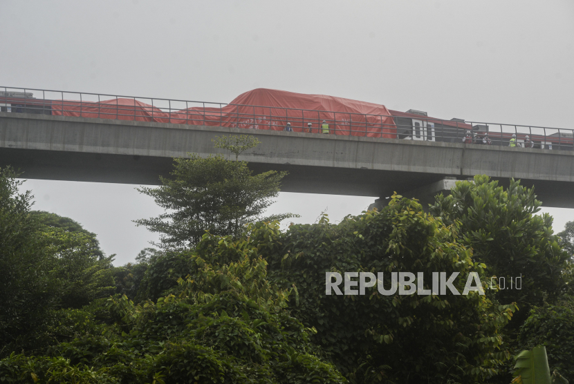 Petugas mengecek kereta LRT yang mengalami kecelakaan di kawasan Cibubur, Jakarta, Senin (25/10). Dua kereta LRT Jabodebek yang masih dalam tahap uji coba mengalami kecelakaan di jalur layang ruas Cibubur-TMII pada pukul 12.30 WIB hingga kini masih dalam tahap pemeriksaan. 