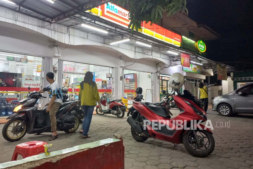 Juru parkir memarkirkan kendaraan di sebuah minimarket kawasan Srengseng Sawah, Jagakarsa, Jakarta Selatan, Ahad (5/5/2024). 