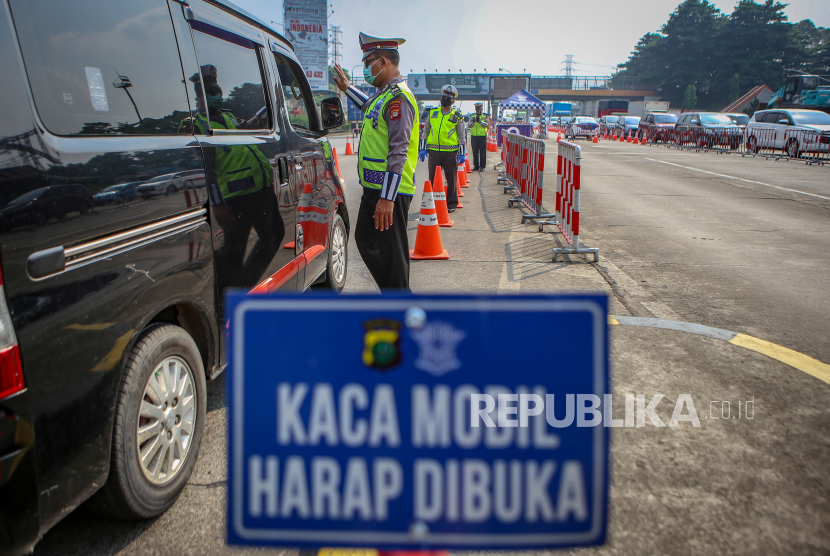 Petugas kepolisian memeriksa kendaraan di gerbang tol Cikupa, Kabupaten Tangerang, Banten, Selasa (19/5/2020). Pemeriksaan kendaraan tersebut sebagai tindak lanjut atas imbauan untuk tidak mudik dan Pembatasan Sosial Berskala Besar (PSBB) guna memutus mata rantai penyebaran COVID-19