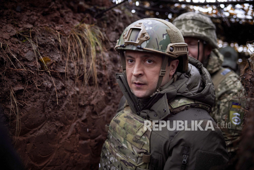  Presiden Ukraina Volodymyr Zelenskyy, berjalan di bawah jaring kamuflase di parit saat ia mengunjungi wilayah Donetsk yang dilanda perang, Ukraina timur, Senin, 6 Desember 2021. Anggota parlemen AS usulkan RUU gelontorkan 300 juta dolar AS untuk militer Ukraina.