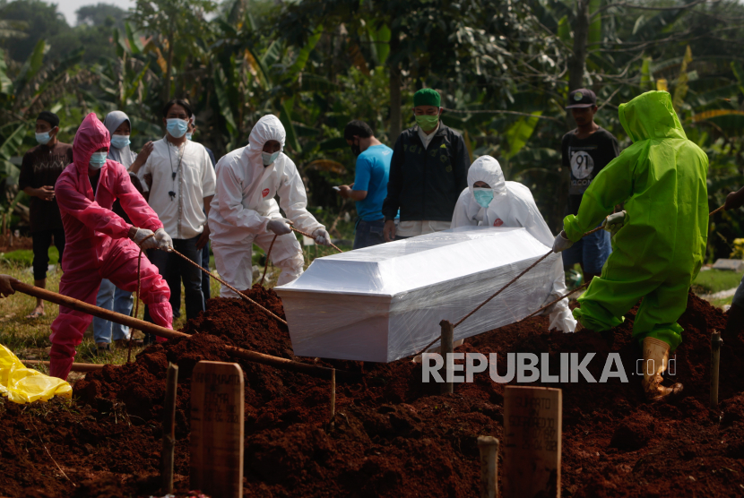  Pekerja yang mengenakan APD menguburkan seseorang yang meninggal karena Covid-19 saat pemakaman (ilustrasi)