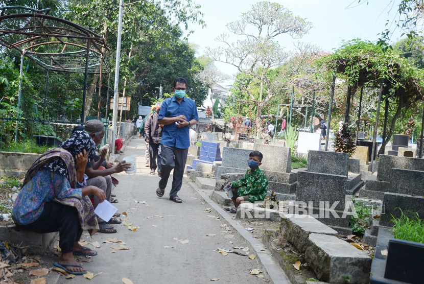 Sejumlah pengemis berharap sedekah dari peziarah di Tempat Pemakaman Umum (TPU) Cikutra, Kota Bandung, Jumat (14/5). Menurut warga sekitar TPU, banyaknya peziarah pada Lebaran ini turun. Hal tersebut dimungkinkan akibat pelarangan mudik oleh pemerintah dengan penyekatan jalur untuk para pemudik. 