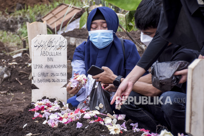 Anggota keluarga menabur bunga usai prosesi pemakaman keluarganya di TPU Cikadut, Jalan Cikadut, Mandalajati, Kota Bandung, Selasa (26/1). Pada Rabu (27/1), angka kematian harian di Indonesia kembali mencetak rekor baru dengan 387 kasus kematian per hari. (ilustrasi)