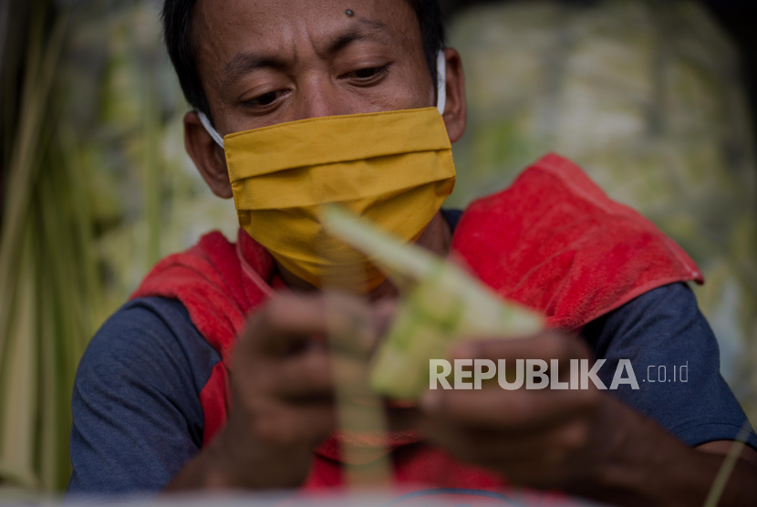 Pedagang membuat cangkang ketupat di kawasan Pasar Jatinegara, Jakarta.