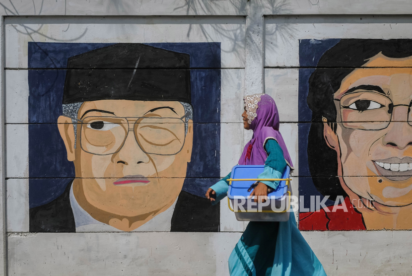 Warga melintas di depan mural wajah Presiden Indonesia keempat Abdurrahman Wahid (kiri) di Leuwidamar, Lebak, Banten. (ilustrasi)