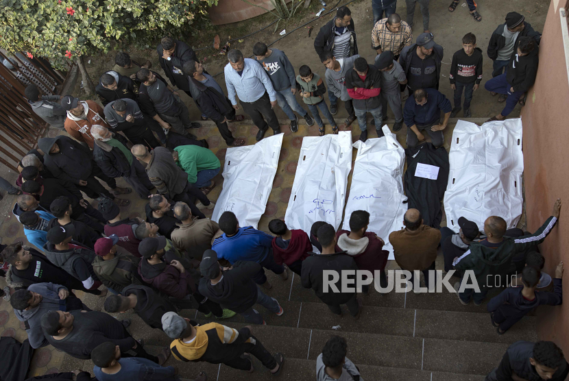 Kerabat warga Palestina yang terbunuh berkumpul di dekat jenazah mereka di Rumah Sakit Nasser di Khan Yunis, Jalur Gaza selatan, 27 Desember 2023.