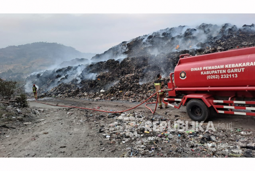 Petugas Dinas Pemadam Kebakaran Garut berupaya memadamkan api dan mengatasi kepulan asap di TPA Pasir Bajing, Kecamatan Banyuresmi, Kabupaten Garut, Jawa Barat, Rabu (5/7/2023).