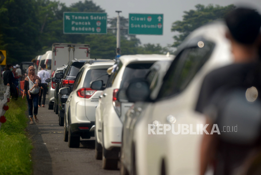 Pengendara keluar dari kendaraanya ketika terjebak kemacetan di Ruas Tol Jagorawi saat menuju kawasan Puncak, Ciawi, Bogor, Jawa Barat, Jumat (6/5/2022). 