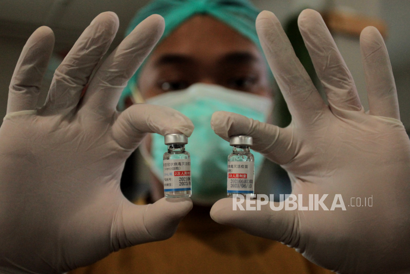 Petugas kesehatan menunjukkan vaksin yang akan disuntikkan kepada warga saat Vaksinasi COVID-19 Gotong Royong di kawasan industri Rungkut, Surabaya, Jawa Timur, Ahad (8/8/2021). Vaksinasi COVID-19 yang digelar salah satu perusahaan di kawasan industri tersebut menyasar pekerja serta keluarganya dengan target penerima vaksin sekitar 800 orang. 