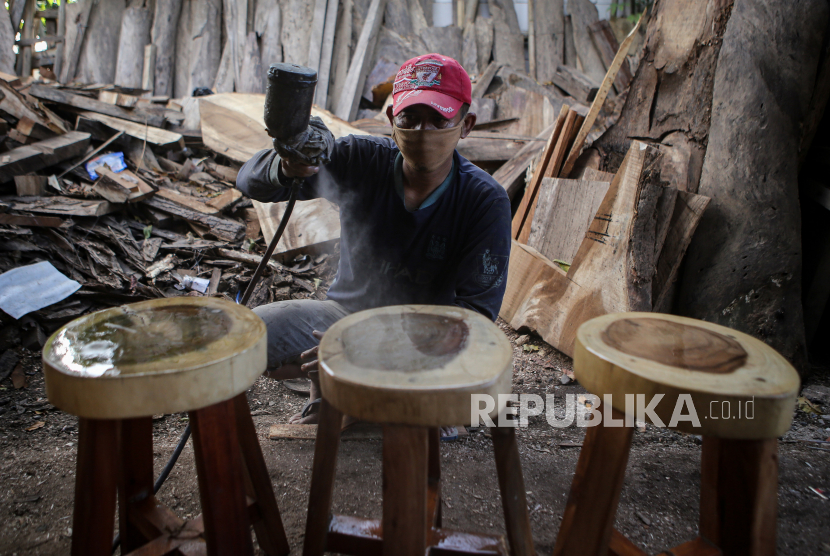 Perajin menyelesaikan pembuatan kursi dari kayu bekas di Pinang, Kota Tangerang, Banten, Selasa (23/3/2021). 