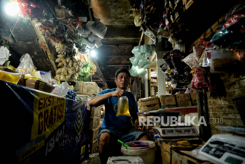 Pedagang mengemas minyak curah di lapaknya di Pasar Minggu, Jakarta, Rabu (29/6/2022). Pemerintah berencana akan menerapkan aturan baru terkait penggunaan aplikasi Peduli Lindungi saat transaksi penjualan dan oembelian minyak goreng curah pada 11 Juli mendatang. Republika/Thoudy Badai