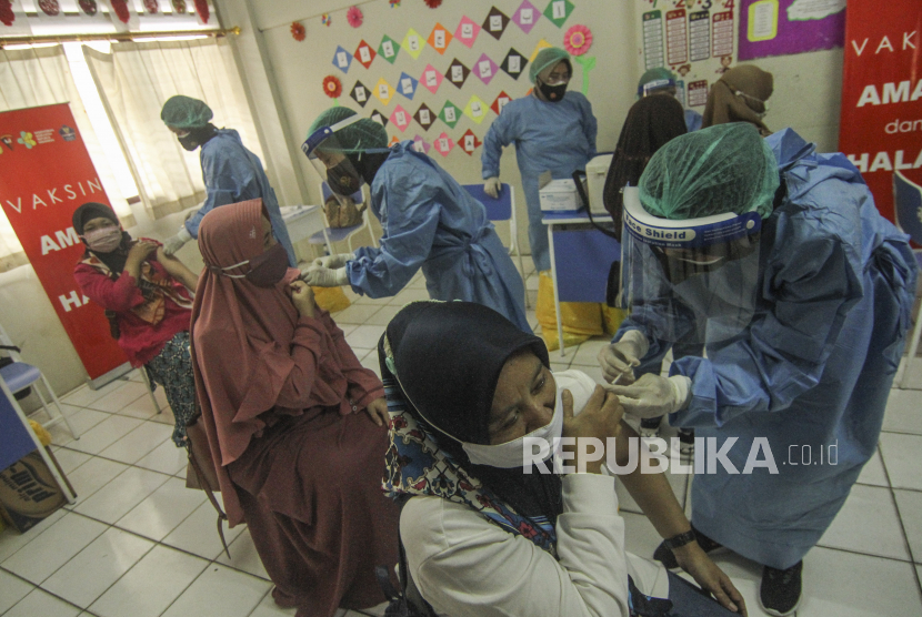 Tenaga medis menyuntikan vaksin COVID-19 kepada sejumlah guru di SDIT Al-Muhajirin, Depok, Jawa Barat, Selasa (18/5/2021). Vaksinasi kepada 2.000 orang dengan sasaran guru dan petugas sekolah tersebut dilakukan untuk mempercepat program vaksinasi COVID-19 sekaligus persiapan untuk pembelajaran tatap muka di Kota Depok. 