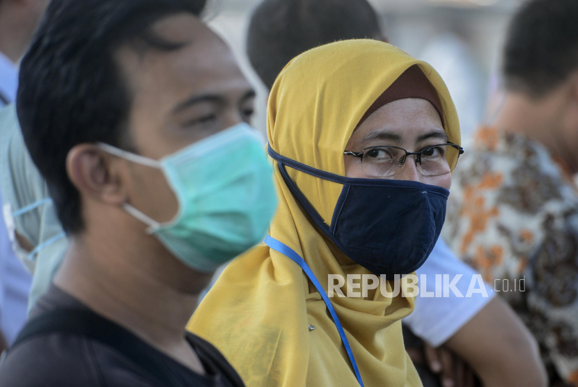 Sejumlah penumpang memakai masker saat menunggu kereta di Stasiun Depok, Depok, Jawa Barat, Jumat (6/3).