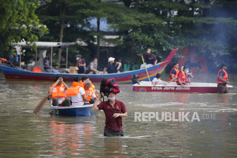 Tim penyelamat mengevakuasi warga di atas perahu di daerah perumahan yang terendam banjir di Shah Alam, di pinggiran Kuala Lumpur, Malaysia, Senin, 20 Desember 2021. Malaysia kucurkan 50 juta ringgit untuk membantu puluhan ribu warga terdampak banjir.