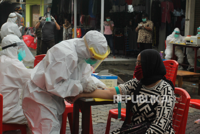Petugas medis melakukan tes cepat di Pasar Sore Manukan, Kota Surabaya, Jawa Timur, Jumat (22/5).