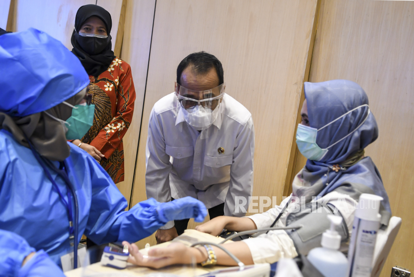 Menteri Perhubungan (Menhub) Budi Karya Sumadi (tengah) menyaksikan vaksinasi COVID-19 bagi pegawai Kemenhub di Jakarta, Kamis (11/3/2021). Vaksinasi COVID-19 diberikan kepada 10.000 pegawai Kemenhub yang berada di wilayah Jabodetabek untuk mencegah penyebaran COVID-19. ANTARA FOTO/M Risyal Hidayat/aww.