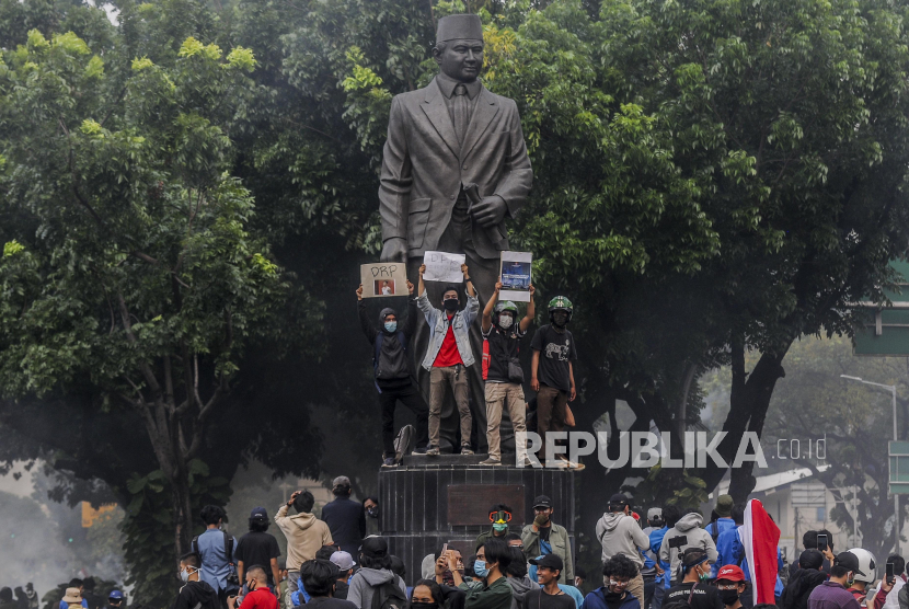 Sejumlah massa aksi memperlihatkan poster saat unjuk rasa di Jakarta, Kamis (8/10). Dalam aksi yang berakhir ricuh tersebut mereka menolak disahkannya Undang-Undang Cipta Kerja (Omnibus Law) karena dinilai merugikan buruh dan pekerja. Republika/Putra M. Akbar