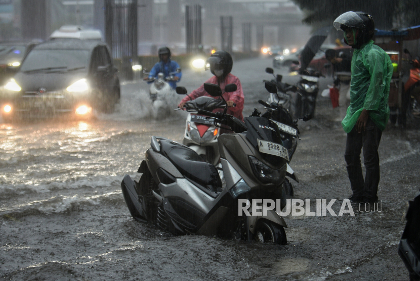 Pengendara memarkir motornya di bahu jalan yang tergenang air di jalan H.R Rasuna Said, Jakarta, Rabu (3/4/2024). Genangan tersebut disebabkan oleh intensitas hujan yang tinggi serta aliran drainase yang meluap sehingga menyebabkam lalu lintas tersendat.