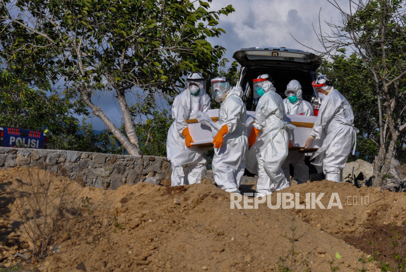 Sejumlah petugas mengangkat peti jenazah seorang Pasien Dalam Pengawasan (PDP) COVID-19 dari kendaraan untuk dimakamkan di Tempat Pemakaman Umum (TPU) Poboya, Palu, Sulawesi Tengah, Senin (11/5/2020). PDP berusia 56 tahun itu meninggal dunia dalam perawatan di Rumah Sakit Undata Palu