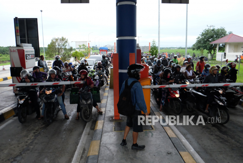 Pengendara sepeda motor masuk ke gerbang tol akibat banjir (ilustrasi).