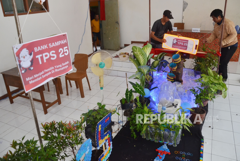 Warga menyiapkan Tempat pemungutan Suara (TPS) bertemakan Bank Sampah di TPS 25, Jalan Lio Genteng, Kelurahan Nyengseret, Kecamatan Astanaanyar, Kota Bandung, Jawa Barat, Selasa (13/2/2024). Untuk menghias TPS warga memanfaatkan barang-barang bekas, dan limbah seperti botol plastik dan kemasan kopi. Pencoblosan Pemilu 2024 akan dilaksanakan pada tanggal 14 Ferbruari 2024.