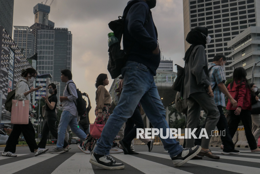 Pekerja menyeberang pelican crossing saat jam pulang kerja di kawasan Sudirman, Jakarta, Senin (5/5/2025). Badan Pusat Statistik (BPS) mencatat tambahan orang yang terdampak pemutusan hubungan kerja (PHK) pada Februari 2025 bertambah sebanyak 83.450 orang dibandingkan Februari 2024. Dengan tambahan tersebut, jumlah total pengangguran di Indonesia sebanyak 7,28 juta orang.
