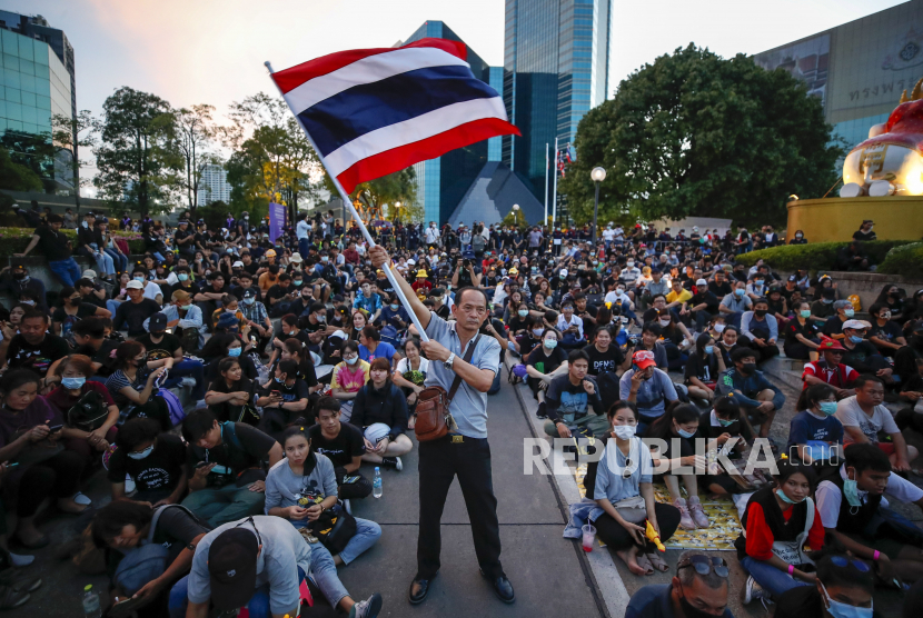  Junta Thailand akan Jabat PM Dua Tahun Lagi. Foto:  Seorang pengunjuk rasa anti-pemerintah mengibarkan bendera nasional Thailand yang besar selama protes yang menyerukan reformasi monarki di markas Siam Commercial Bank di Bangkok, Thailand, 25 November 2020. Pengunjuk rasa anti-pemerintah mengadakan rapat umum yang menyerukan reformasi monarki di Siam Commercial Bank dimana Thai King secara pribadi telah menjadi pemegang saham utama. Politik Thailand diintensifkan oleh protes jalanan selama berbulan-bulan yang menyerukan reformasi politik dan monarki dan pengunduran diri perdana menteri. 