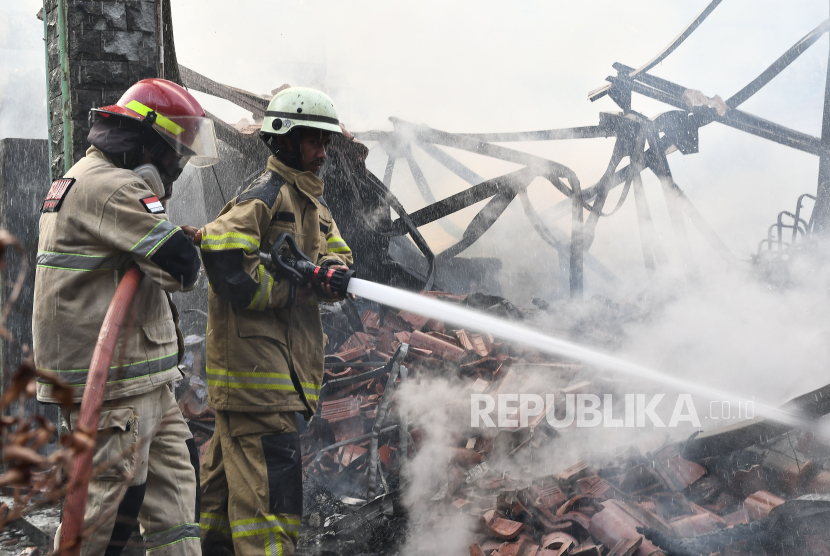 Dua petugas pemadam kebakaran berupaya memadamkan api saat terjadi kebakaran di pendopo Kantor Kecamatan Bekasi Selatan, Pekayon Jaya, Bekasi, Jawa Barat, Jumat (11/10/2024). Sebanyak enam unit mobil pemadam diturunkan untuk memguasai api, sementara penyebab kebakaran masih dalam penyelidikan pihak terkait. 