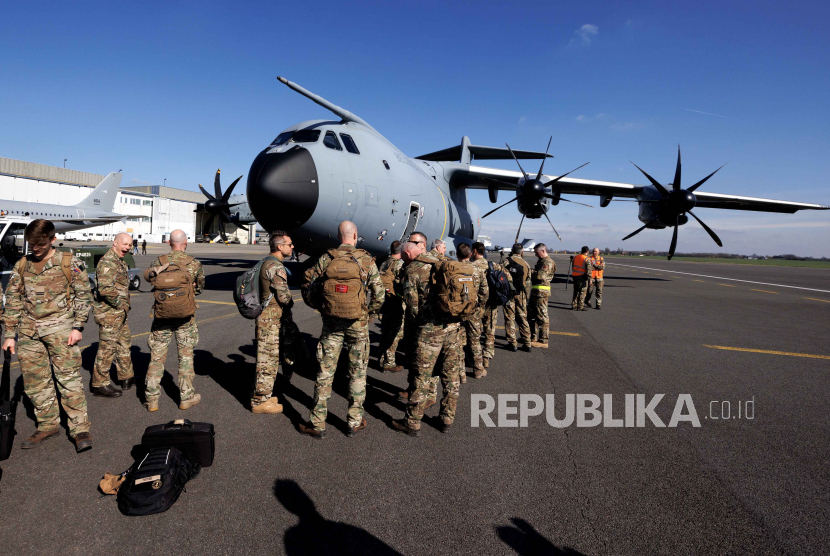 Personel militer menunggu di depan Atlas Airbus A400M Angkatan Udara Belgia yang membawa bantuan kemanusiaan untuk diturunkan ke Gaza. 