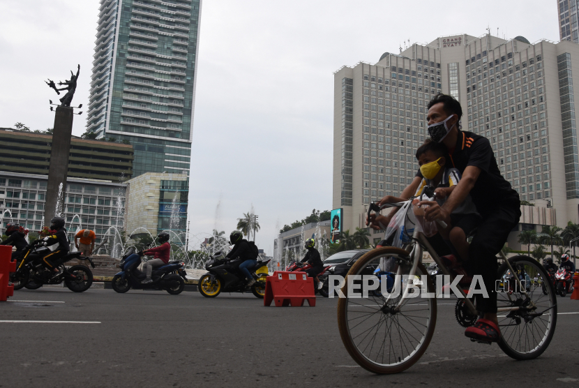 Warga mengendarai sepedanya saat berolahraga di kawasan Bundaran HI, Jakarta, Ahad (20/09/2020). Aktivitas warga di kawasan tersebut mulai berkurang seiring diberlakukannya Pembatasan Sosial Berskala Besar (PSBB) total di Jakarta. 
