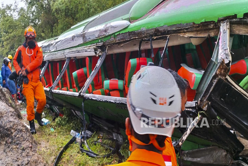 Sebuah foto selebaran yang disediakan oleh Badan Pencarian dan Pertolongan Nasional Indonesia (BASARNAS) menunjukkan tim penyelamat memeriksa bus yang jatuh di Bantul, Yogyakarta, 06 Februari 2022. Sedikitnya 13 penumpang tewas setelah bus wisata menabrak tebing.