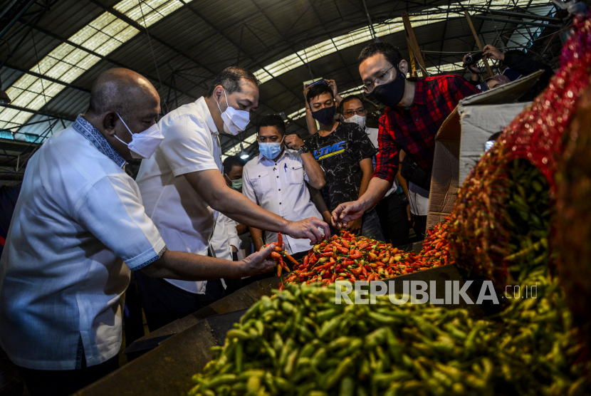 Menteri Perdagangan Muhammad Lutfi (kedua kiri) melihat cabai saat meninjau harga dan stok bahan pokok di Pasar Induk Kramat Jati, Jakarta, Rabu (7/4). Konsumsi komoditas pangan di sejumlah wilayah Jakarta, Bogor, Depok, Tangerang, Bekasi (Jabodetabek) dan Bandung Raya akan meningkat. 