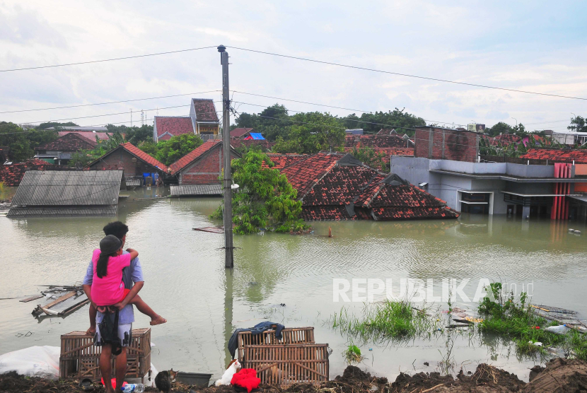 Warga menyaksikan rumah yang terendam banjir di Desa Ketanjung, Karanganyar, Demak, Jawa Tengah, Ahad  (17/3/2024). Badan Penanggulangan Bencana Daerah (BPBD) setempat mencatat banjir yang menerjang Kabupaten Demak sejak Rabu (13/3) hingga Ahad   (17/3) karena jebolnya tanggul Sungai Irigasi Jratunseluna serta tanggul Sungai Wulan itu menyebabkan ribuan rumah terendam dan 27.254 KK di 88 desa dari 11 kecamatan terdampak. ANTARA FOTO/Yusuf Nugroho/nym.