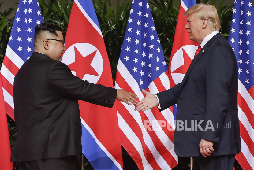 Presiden AS Donald Trump, kanan, berjabat tangan dengan pemimpin Korea Utara Kim Jong Un di resor Capella di Pulau Sentosa di Singapura pada 12 Juni 2018. 