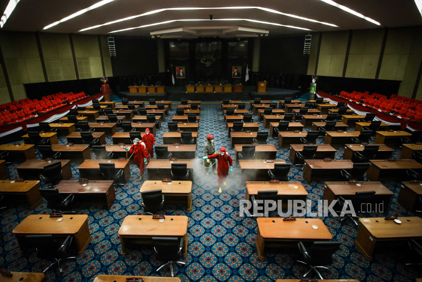 Petugas menyemprotkan cairan disinfektan di ruang sidang paripurna DPRD DKI Jakarta, Rabu (29/7/2020). DPRD DKI saat ini tengah disorot terkait isu anggaran DPRD dalam APBD DKI 2021. (ilustrasi)