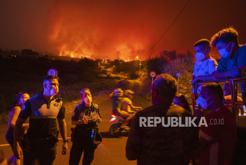 Penduduk setempat mencoba untuk ke rumah mereka di desa Benijos saat polisi memblokir area tersebut saat kebakaran meluas di La Orotava di Tenerife, Kepulauan Canary, Spanyol,  Ahad, (20/8/2023) WIB.