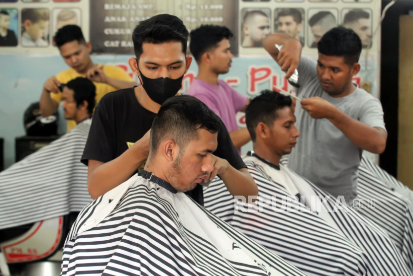 Tukang pangkas rambut mencukur rambut pelanggan di Kota Lhokseumawe, Aceh, Kamis (28/4/2022). Gaya rambut qaza dilarang dalam Islam.