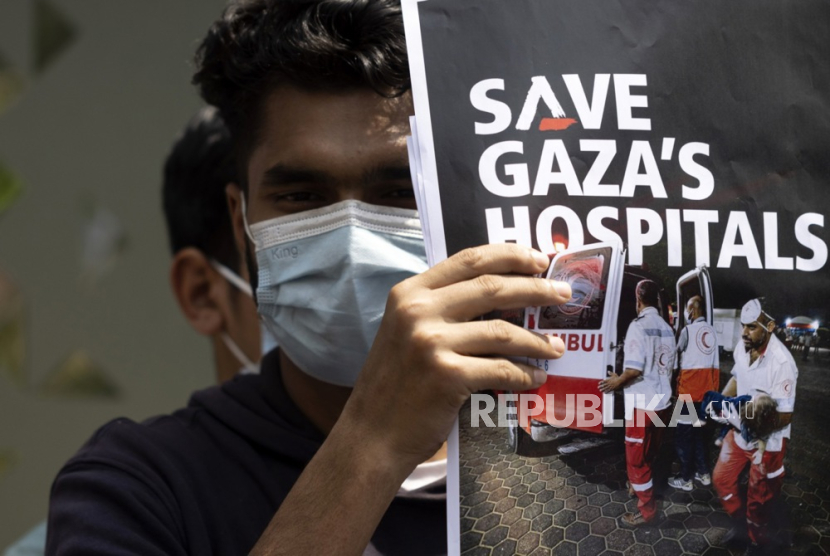 Seorang pria membawa plakat ketika sekelompok dokter Nepal dari rumah sakit pendidikan melakukan protes, menyerukan perdamaian di Gaza, dekat Kedutaan Besar Israel di Kathmandu, Nepal, (29/3/2024),